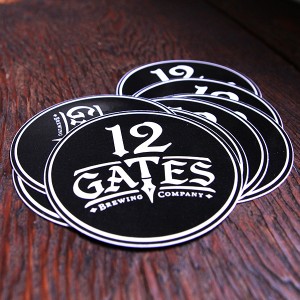 12 Gates Brewing Company stickers. Round black stickers with a white logo centered