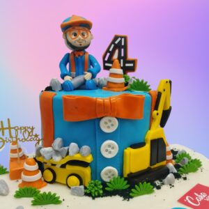 2 Kg Clever Construction Man Birthday shaped like a construction site, featuring edible fondant tools, miniature construction vehicles, and a hardhat-wearing fondant figure. "Happy Birthday" is written on a fondant construction sign.