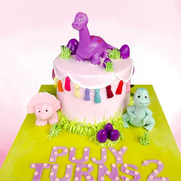 Amazing Dinosaur Girls Birthday Cake 2 Kg.Charming 2 Kg purple dinosaur-themed birthday cake with girly accents and playful decorations.