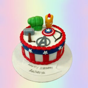 Awesome All Avengers Theme Boys Birthday Cake 1 Kg,Compact yet detailed Avengers-themed cake showcasing multiple superhero emblems and iconic symbols on a round base, perfect for a young Marvel fan's birthday.