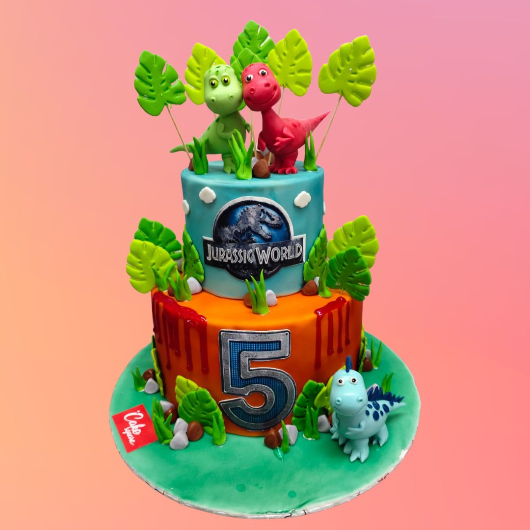 Best 5 Kg Lovely Dinosaur Birthday Cake, this Massive 5kg cake featuring adorable cartoon-style dinosaurs, lush fondant foliage, and a volcanic backdrop, creating a charming prehistoric scene for a child's birthday.