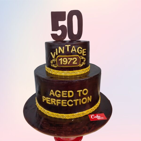 Best 50th Birthday cake 4 Kgs, Elegant gold and white two-tiered cake decorated with intricate patterns, shimmering accents, and a prominent "50" topper, celebrating a milestone birthday.