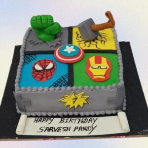 Best Avengers Theme Kids Birthday Cake 3 Kg featuring iconic superhero symbols and figurines. Each tier represents different Avengers characters with their signature colors and emblems. Topped with an edible Avengers logo and "Happy Birthday" message.