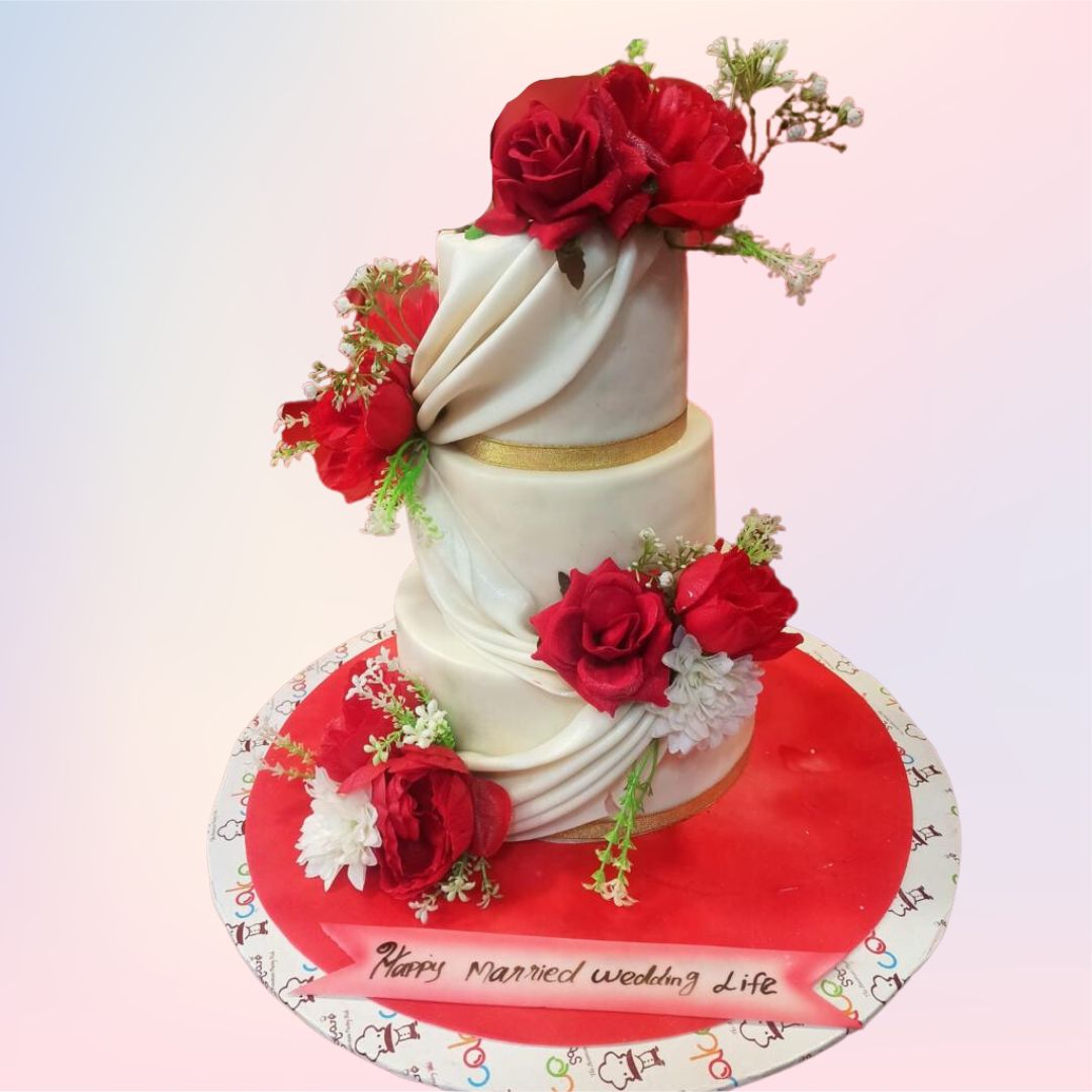 A three tier white cake with wrap arounds and bunches of red roses and white flowers to accentuate is our Bride to be Style Wedding Cake 7 kgs. Made by cake Square Team.