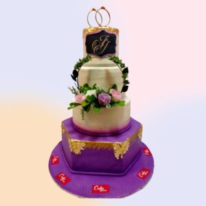 A 4 tier cake which can be made with dummies and cakes as per customers needs finished with purple and white and a small flower circle in the middle layers and the couples initials engraved on the tope layer with beautiful wedding rings on top is our Bride to be cake 3 tier wedding cake.Made by Cake Square Team
