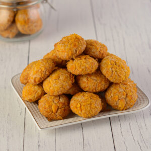 Crunchy Cornflakes Cookies-150 gms. Golden-brown, textured cornflakes cookies piled in a 150g serving.