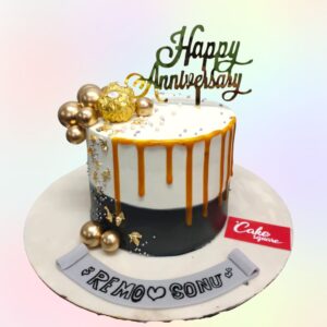 A simple white and gold with caramel dripping from the top and a cute happy anniversary cake topper made by Cake Square.