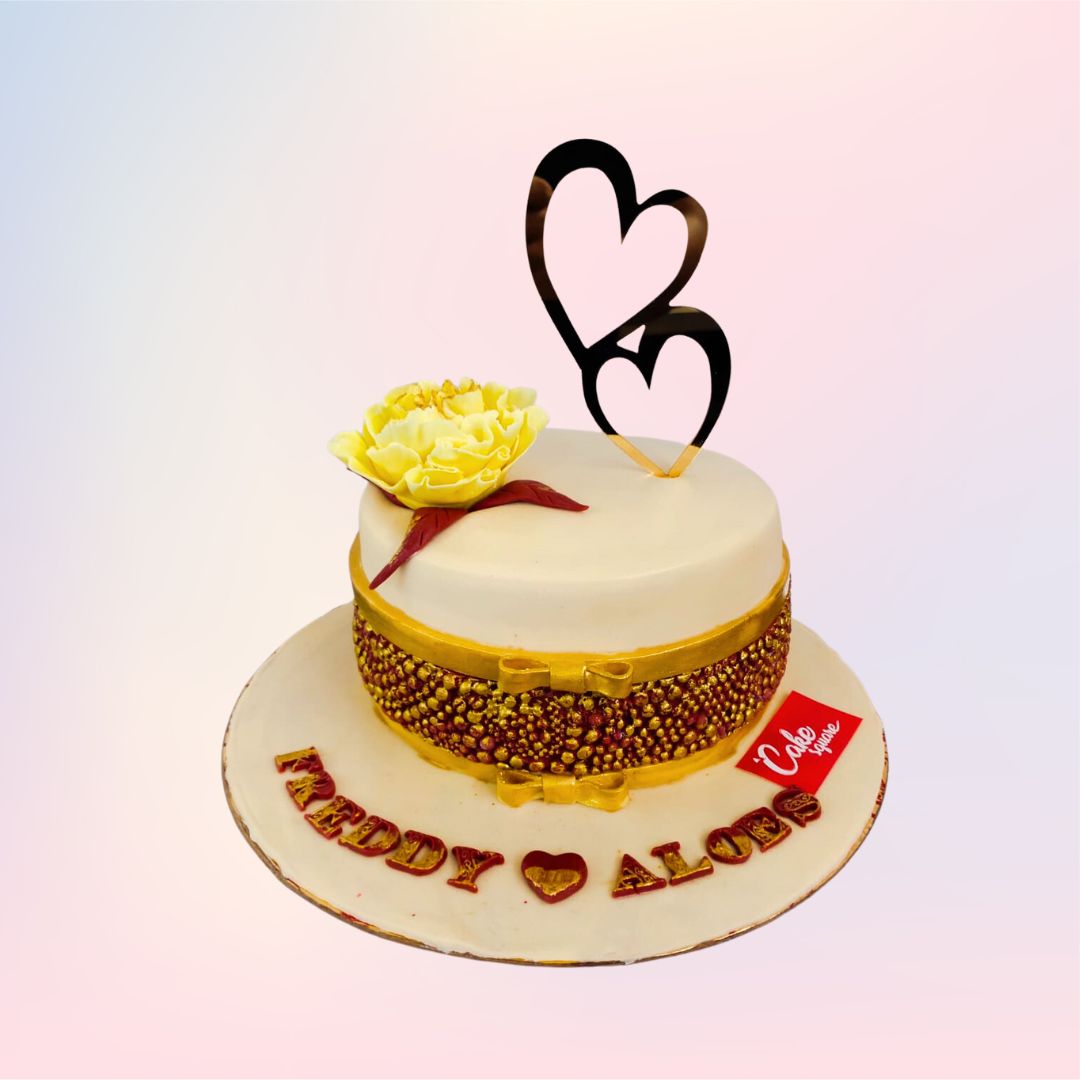 Double heart topper and a single flower with golden sprinkles on the side with a touch of red Fancy 1 Kg Anniversary Cake made by Cake Square Team.