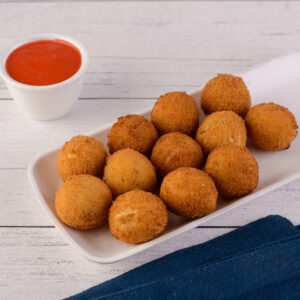 Fresh Cheese Balls -4 pieces. Four soft, white fresh cheese balls dusted with herbs on a serving plate.