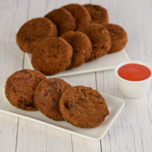 Fresh Veg Cutlet 80 Grams. Golden-brown vegetable cutlet, 80 grams, with visible vegetable bits.