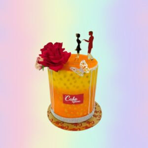 An orange cake with a red rose and a butterfly with a cute young couple topper in Goldie Anniversary Cake 1 Kg by cake square team