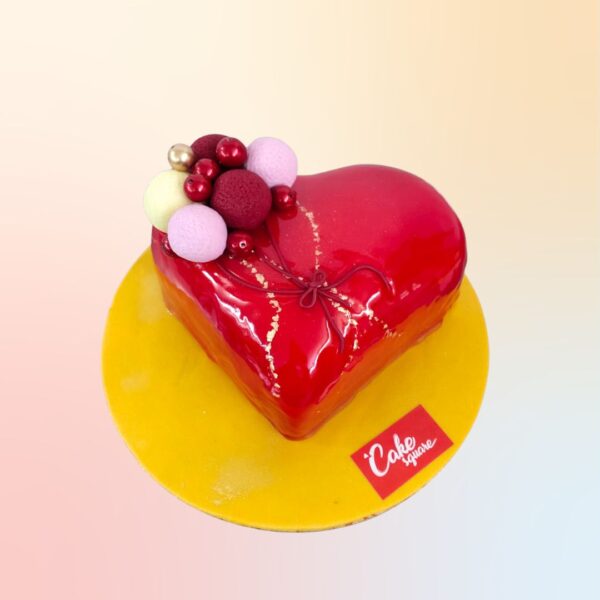 A red heart gel finished cake with a bunch of chocolate faux ball made as balloons on top of the cake is Heart 1Kg Anniversary Cake by Cake Square team.