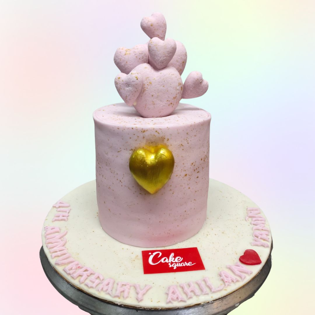 A baby pink cake decorated with baby pink 3 d hearts topped on one another and a golden 3d heart on the middle is our beautiful Hearts Lovers 1 Kg Anniversary Cake made by Cake Square team.