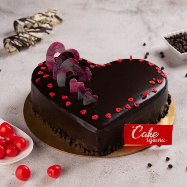 A round 1 Kg Chocolate Truffle Birthday Cake decorated with edible red hearts.