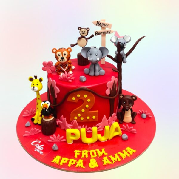 New Animal Theme Birthday Cake 1 Kg featuring fondant jungle animals, lush greenery decorations, and a personalized "Happy Birthday" message. Perfect for animal lovers and safari-themed parties.