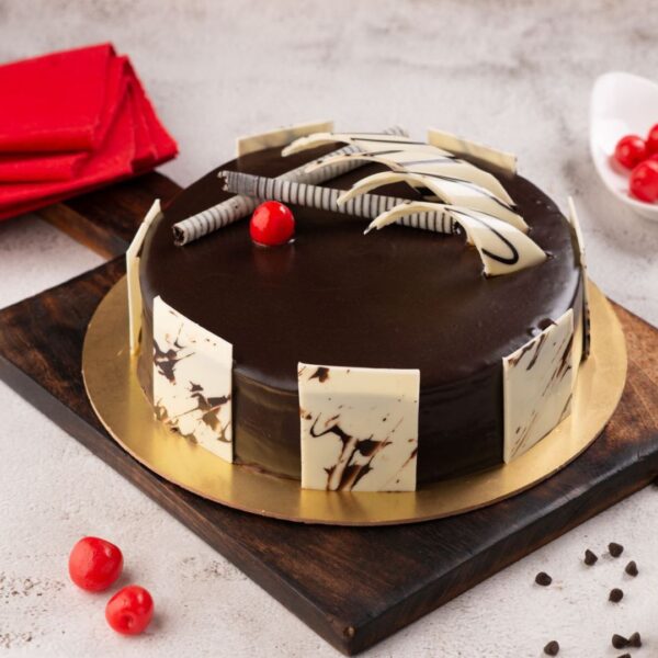 A round 1/2 Kg Punchy Chocolate Birthday Cake with mirror glaze finish, decorated with sharp chocolate shards.