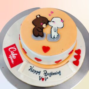 A cream colour cake topped with 2d fondant of two puppies kissing with hearts all over is Puppy Love 1 Kg Anniversary Cake by Cake Square.