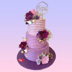 Creamy Purple Beauty Engagement Cake 7 Kg with lavender ombre buttercream, silver drip effect, and a crown of fresh flowers in purple and white hues.