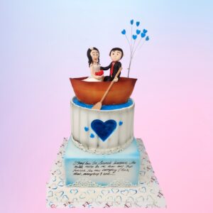 "Cute Couple 2-Tier 4 Kg Boat Theme Wedding Anniversary Cake in Black Forest flavor, perfect for a romantic celebration."