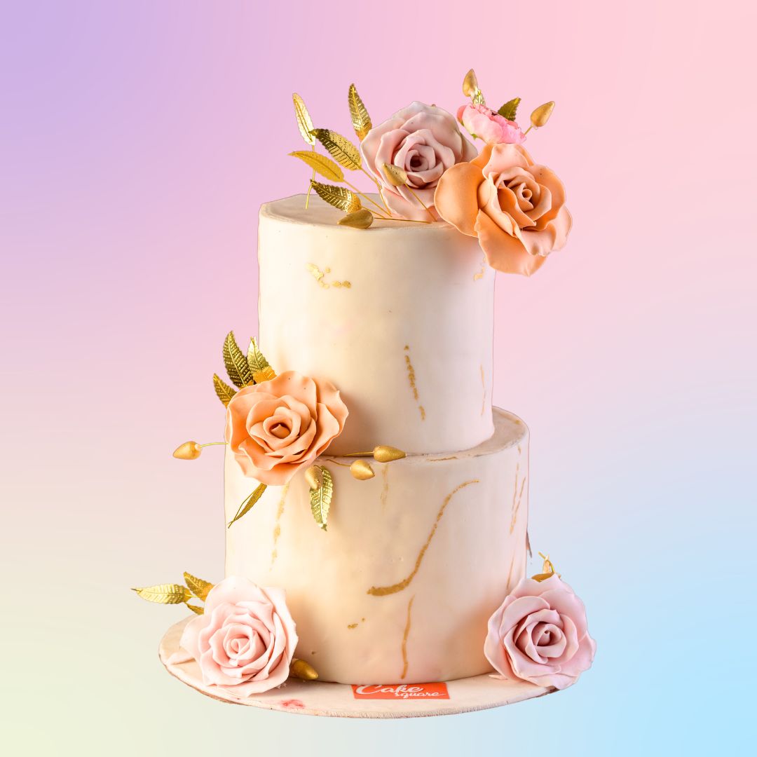 A 2 tier baby pink cake with light marble finish and a bunch of handmade edible roses on focal points and golden leaves. This Perfect engagement Cakes 4 Kg is made by Cake Square Team.