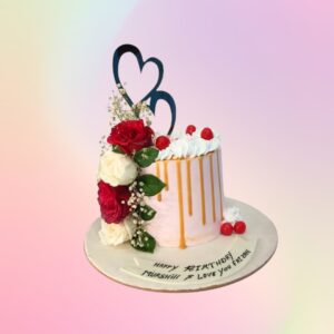 "Flowers and Chocolate Dripping Cake - Anniversary Cake 1 Kg in Black Forest flavour, featuring a beautiful floral design with chocolate drips."