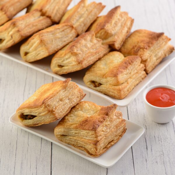 Amazing Veg Puff. Flaky, golden veg puff with visible layers and a peek of the vegetable filling.