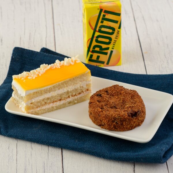 Festive Combo Veg Cutlet and Pastry. Festive plate with a golden vegetable cutlet next to a colorful, decorated pastry.