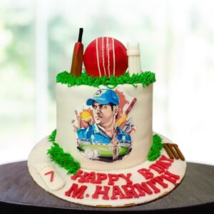 Awesome Dhoni cricket theme birthday cake 2kg. Vibrant 2kg Dhoni-inspired cricket theme birthday cake with bat and ball decorations