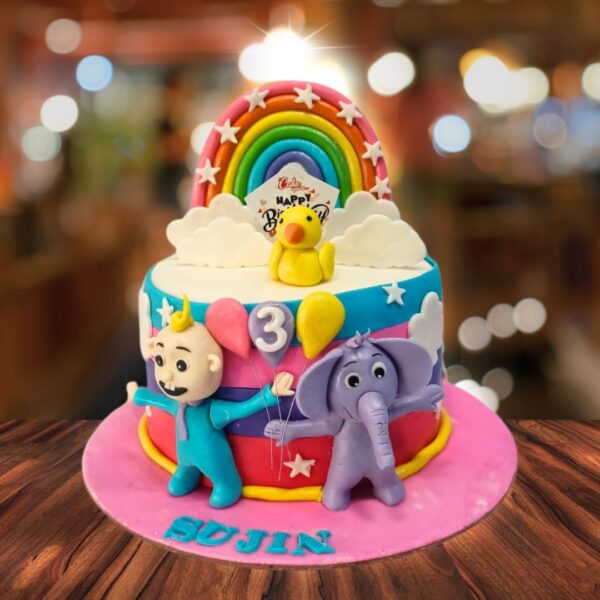 "Cocomelon Rainbow Birthday Cake For Kids 1 Kg with colorful Cocomelon decorations, perfect for a vibrant and fun birthday celebration."