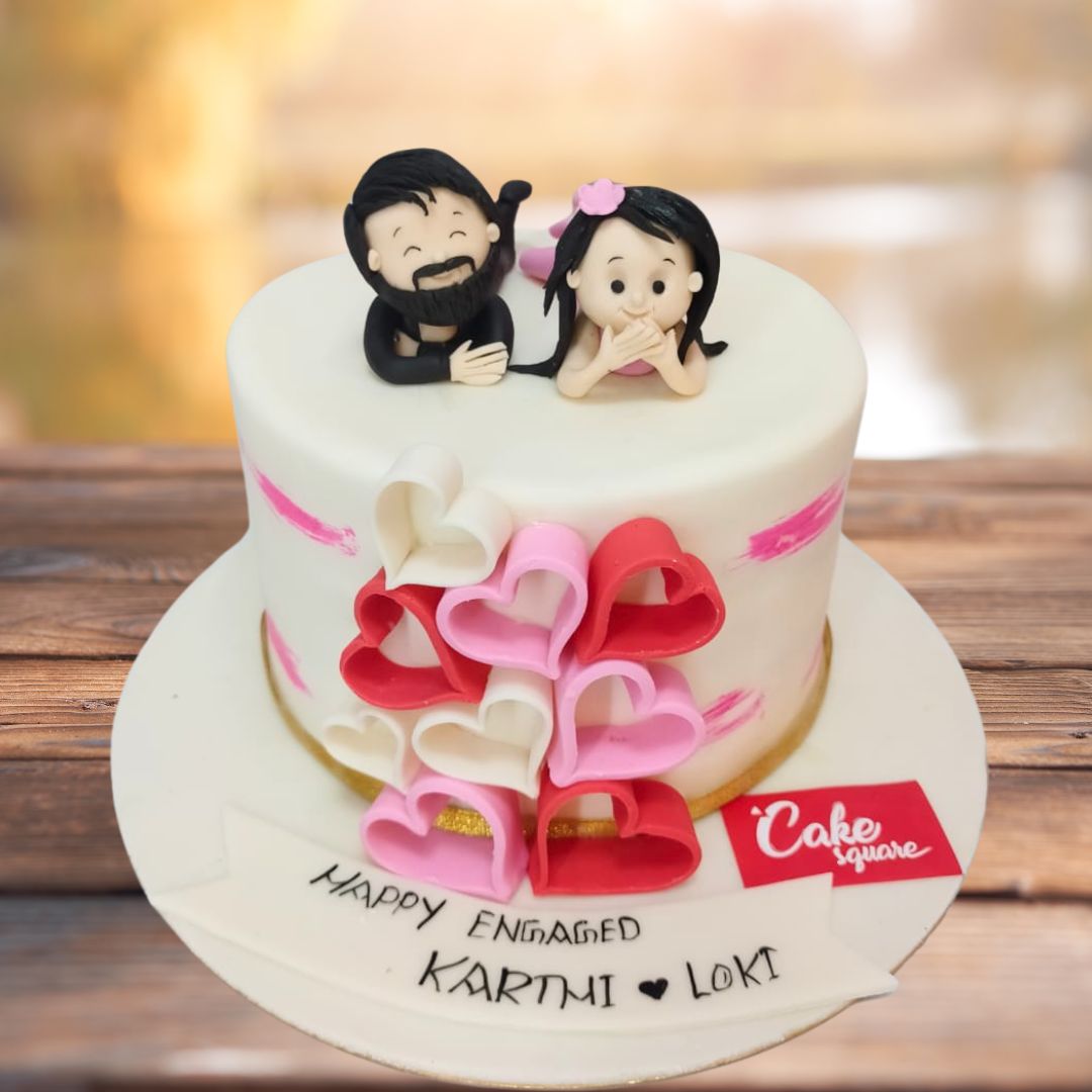 Lovers engagement theme cake 1 Kg with a lovers theme, featuring delicate heart decorations and soft pastel colors perfect for celebrating love.