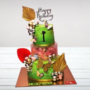 "A vibrant 5 kg first birthday cake featuring multiple tiers separated by a spacer, decorated with colorful fondant designs and a prominent '1' topper."