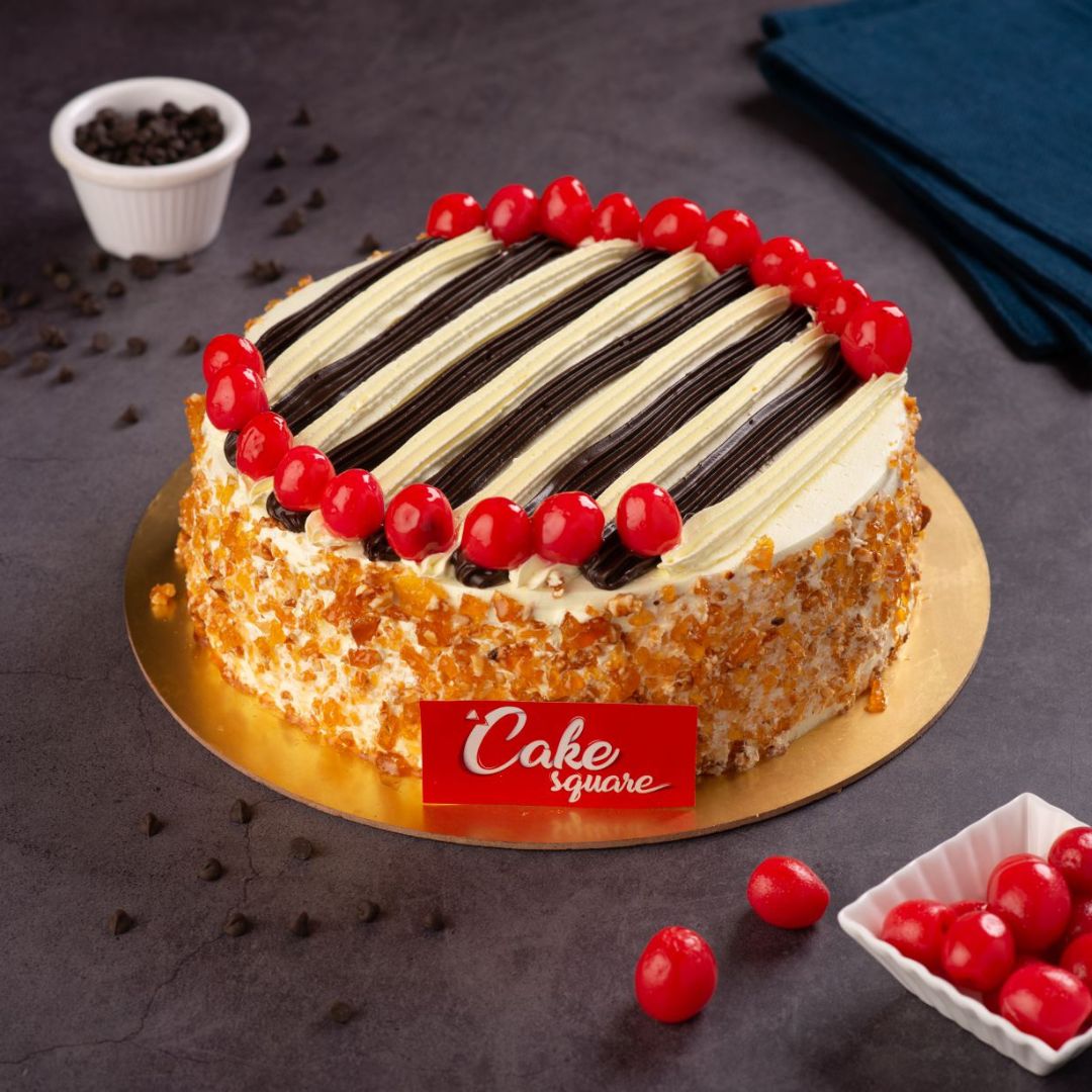 A butterscotch cake made with vanilla sponge butterscotch essence and caramelised cashews, This particular Marble Butter scotch 1/2 Kg Birthday Cake ia also decorated with lines of chocolate pipings and the ends are marked with cherries. Made by cake square team.
