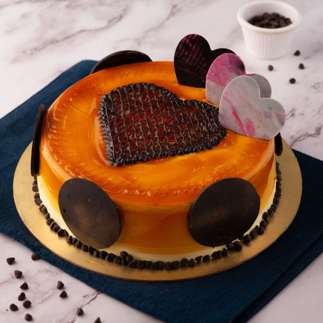 A juicy mango cake decorated with a heart shape net chocolate ganache and more hearts . Its our Heartful Mango1 Kg Birthday Cakes by Cake Square Team