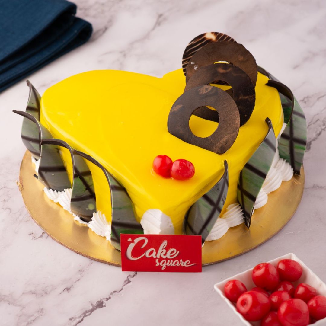A heart shaped Pinapple yellow cake made with vanilla sponge and decorated with some stylish chocolate ganache is our Heartful Mango1 Kg Birthday Cake. Made by Cake Square Team