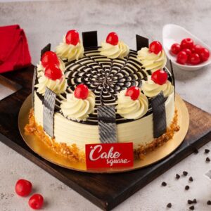 A 1 Kg butter scotch cake made with vanilla sponge and filled with caramelised nuts inside and decorated with chocolate piping on top along with red cherries is our Spiral Butter scotch 1 kg Anniversary Cake. Made by Cake Square tea.