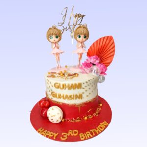 A round 1 kg cake designed for twin girls' birthday. The cake is covered in pastel purple fondant. Two fondant girl figures, each wearing a different colored dress, stand on top. Between them is a large fondant number representing their age, in sparkly pink. The sides of the cake are decorated with fondant butterflies and flowers in various shades of pink and purple. Small fondant hearts are scattered around the figures. The cake's border is piped with white buttercream in a pearl pattern. A banner reading "Happy Birthday Twins" in glittery letters stretches across the front of the cake.