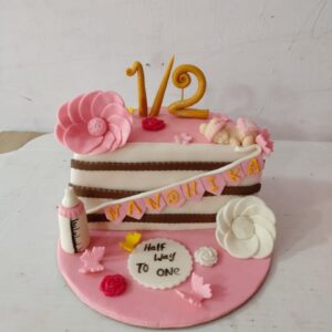 "Girls Pink Theme Half Birthday Cake 1 Kg featuring vibrant pink decorations, perfect for a charming half-birthday celebration."