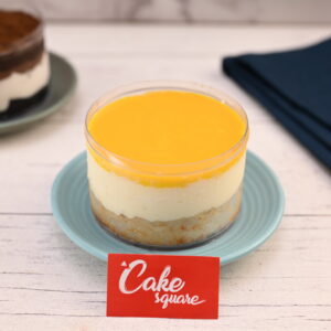 "250 gm personal-sized mango cake with creamy frosting and fresh mango pieces"