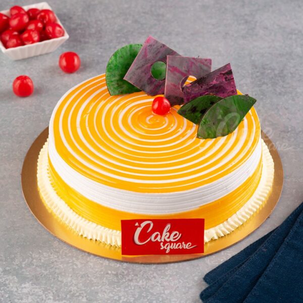 "1 kg birthday cake with swirled mango and vanilla design, topped with mango rosettes"