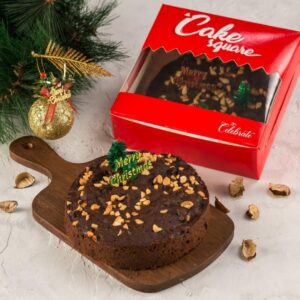 A Christmas Rich Plum cake 400 gms elegantly presented on a holiday-themed table, highlighting its rich texture and festive decorations.