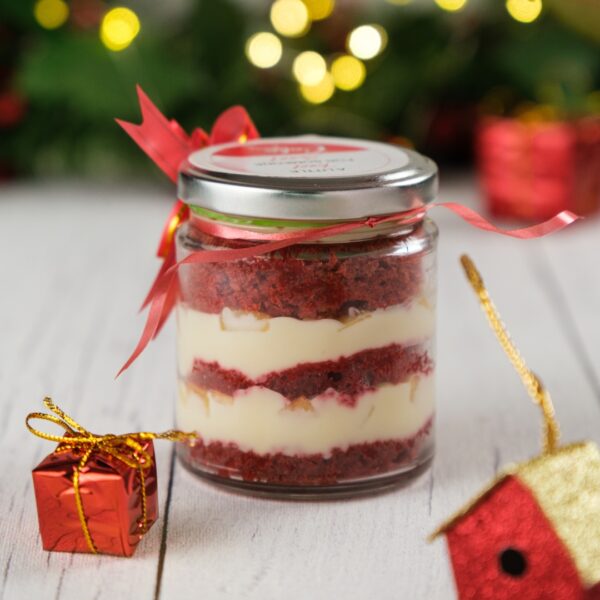 A jar of Delicious Red Velvet Cream Cheese Jar 120 gms with its vibrant layers and creamy texture is perfect for indulging in or gifting it to someone to share the joy of festivities.