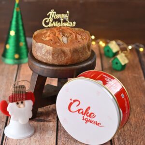 A Gift Tin Ginger Dry cake 250 gms displayed in its decorative tin, ready to be gifted, showcasing its delicious appearance and festive charm.