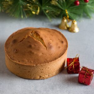 A Happy Christmas Classic Sponge Tea cake 1 kg displayed on a festive table, showcasing its inviting texture and simplicity, perfect for holiday enjoyment.