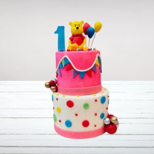 Pink bear-shaped cake with "1" candle for first birthday celebration is our Pink Bear First Birthday Cake 5 kg