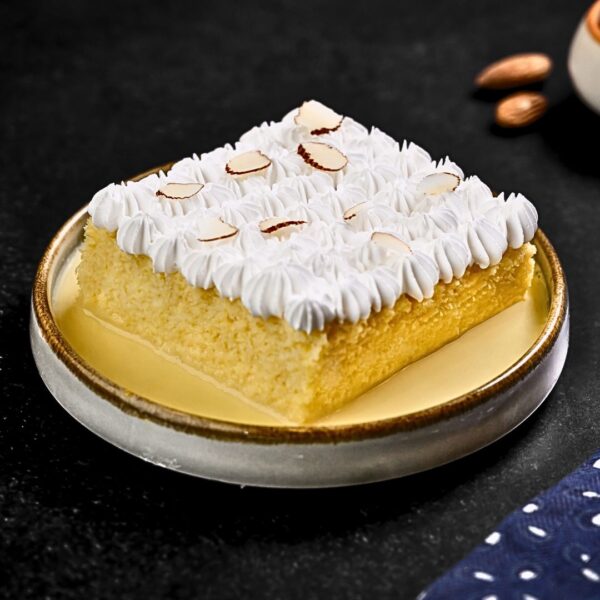 "A decadent 800-gram Butterscotch Tres Leches cake featuring three layers of moist sponge cake soaked in three types of milk, topped with butterscotch sauce, whipped cream rosettes, and butterscotch crumbles."